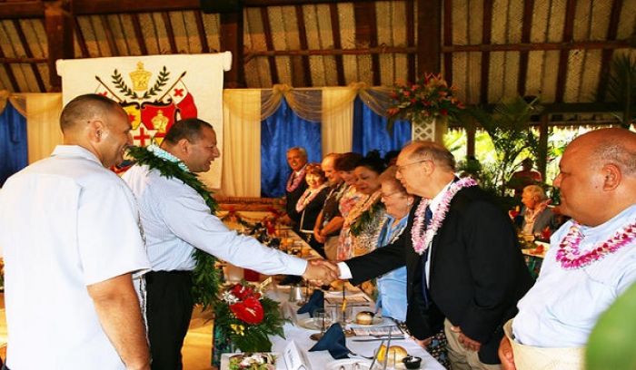 His Majesty King Tupou VI, King of Tonga, second from left, greets Eric Shumway, the former BYU–Hawaii and Polynesian Cultural Center president who holds the Tongan chiefly title Faivaola, during a banquet in the king and queen's honor. PCC president Alfred Grace is to the left; and Elder O. Vincent Haleck a General Authority Seventy and first counselor in the